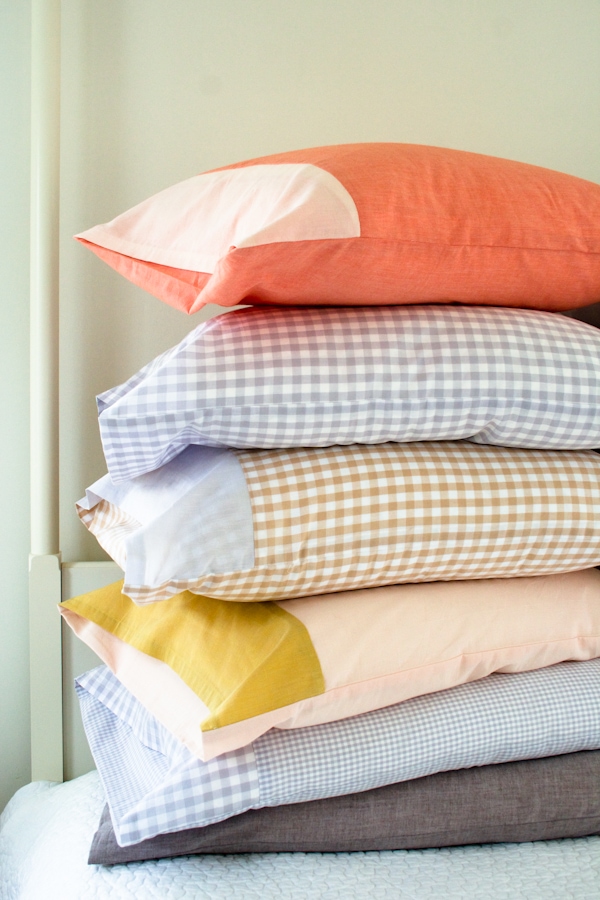 5 pillows with colorful pillowcases stacked on each other