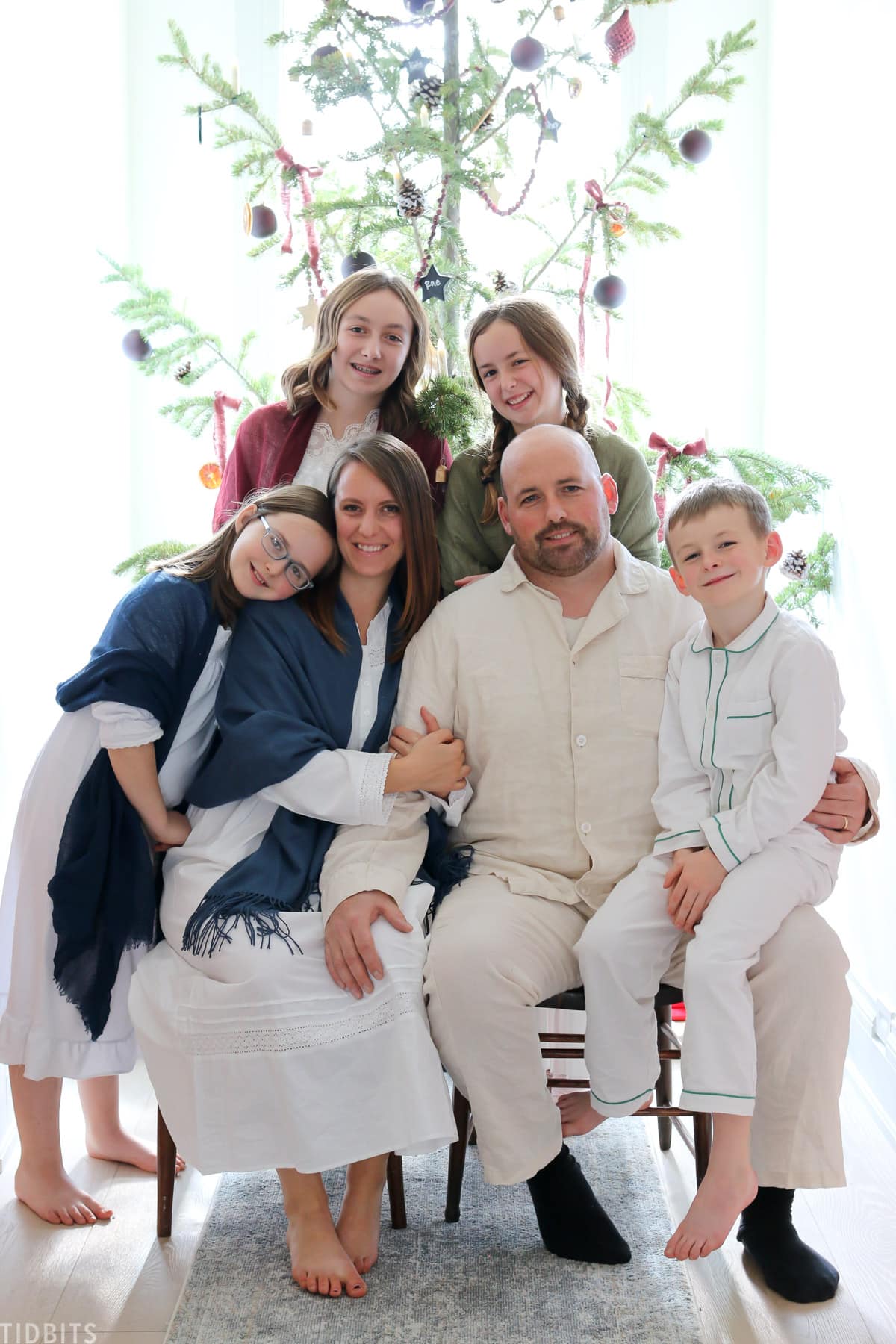 family photo around christmas tree in pajamas