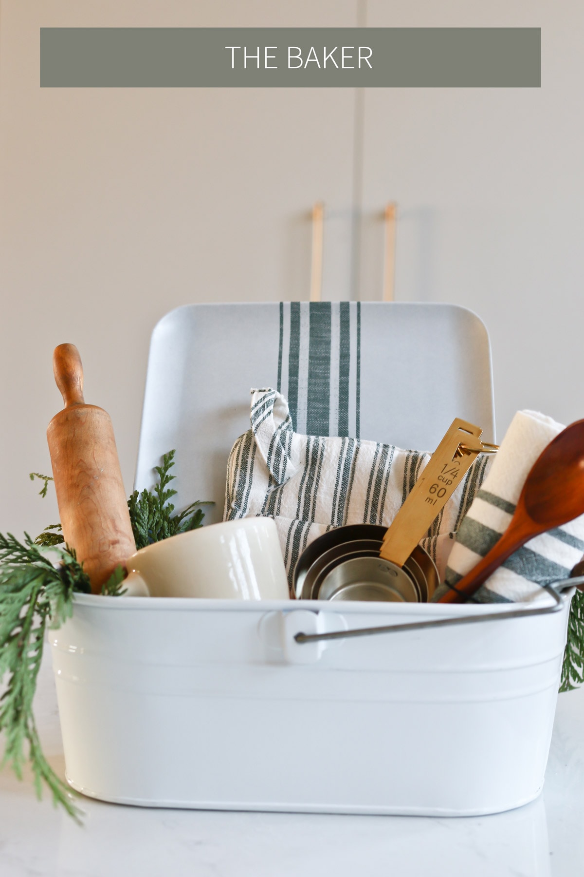 baker gift basket idea for grandma that includes measuring cups, a rolling pin, a wooden spoon, and towels