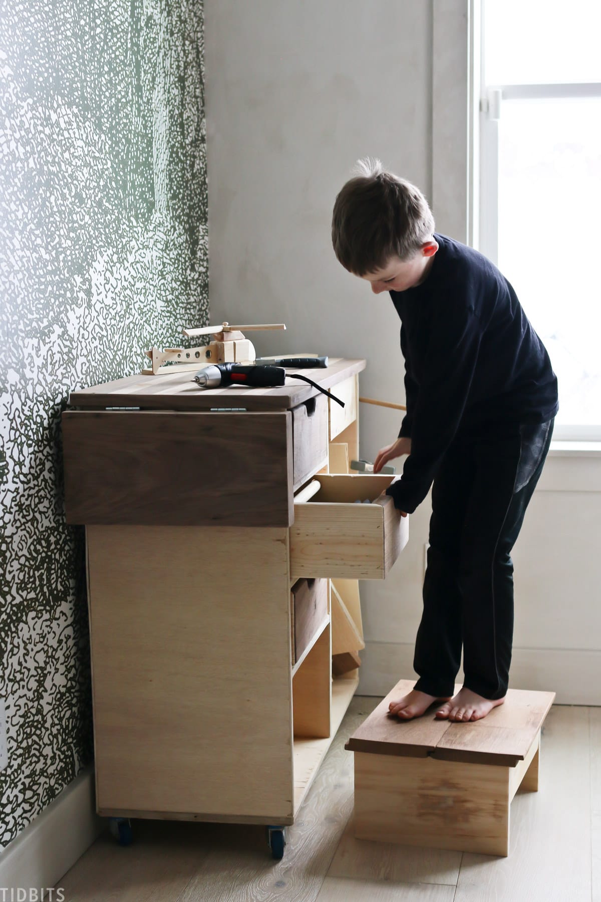 Little boy building on his own workbench