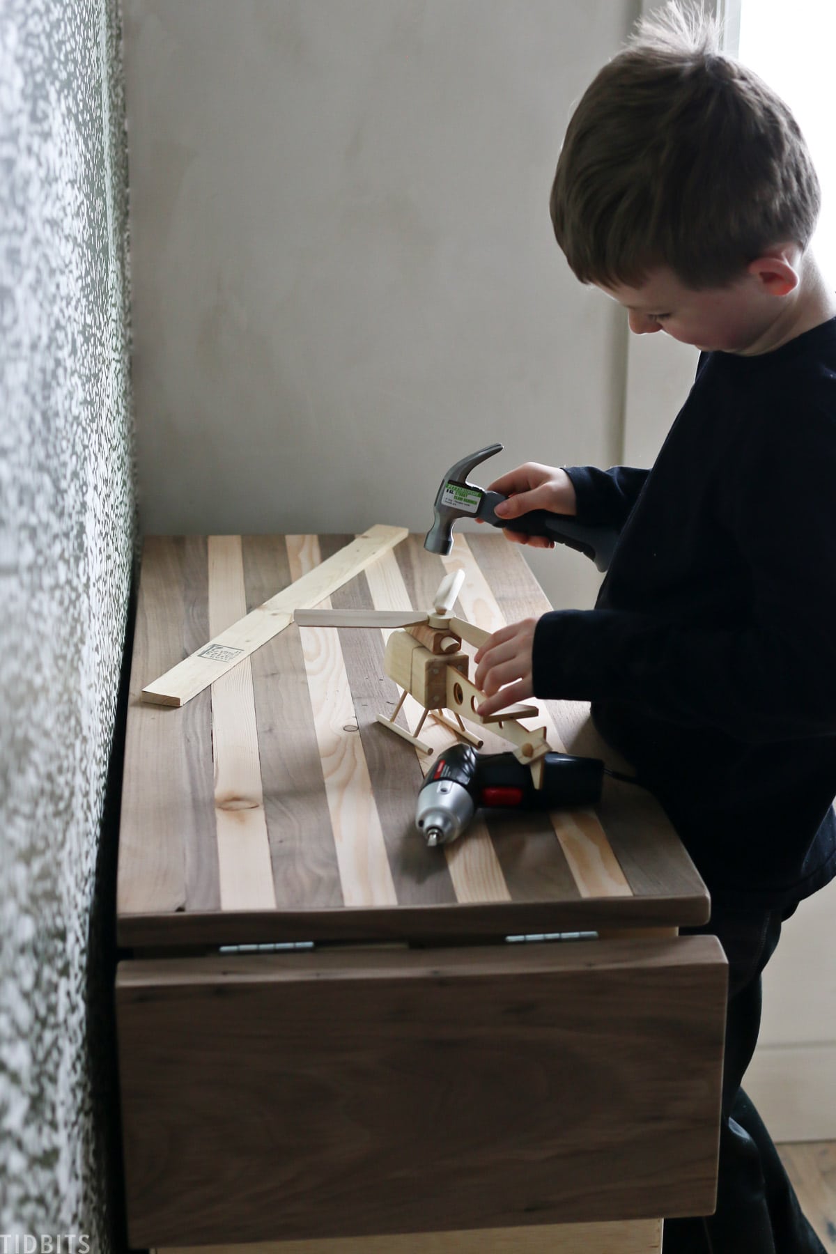 Little boy building on his own workbench