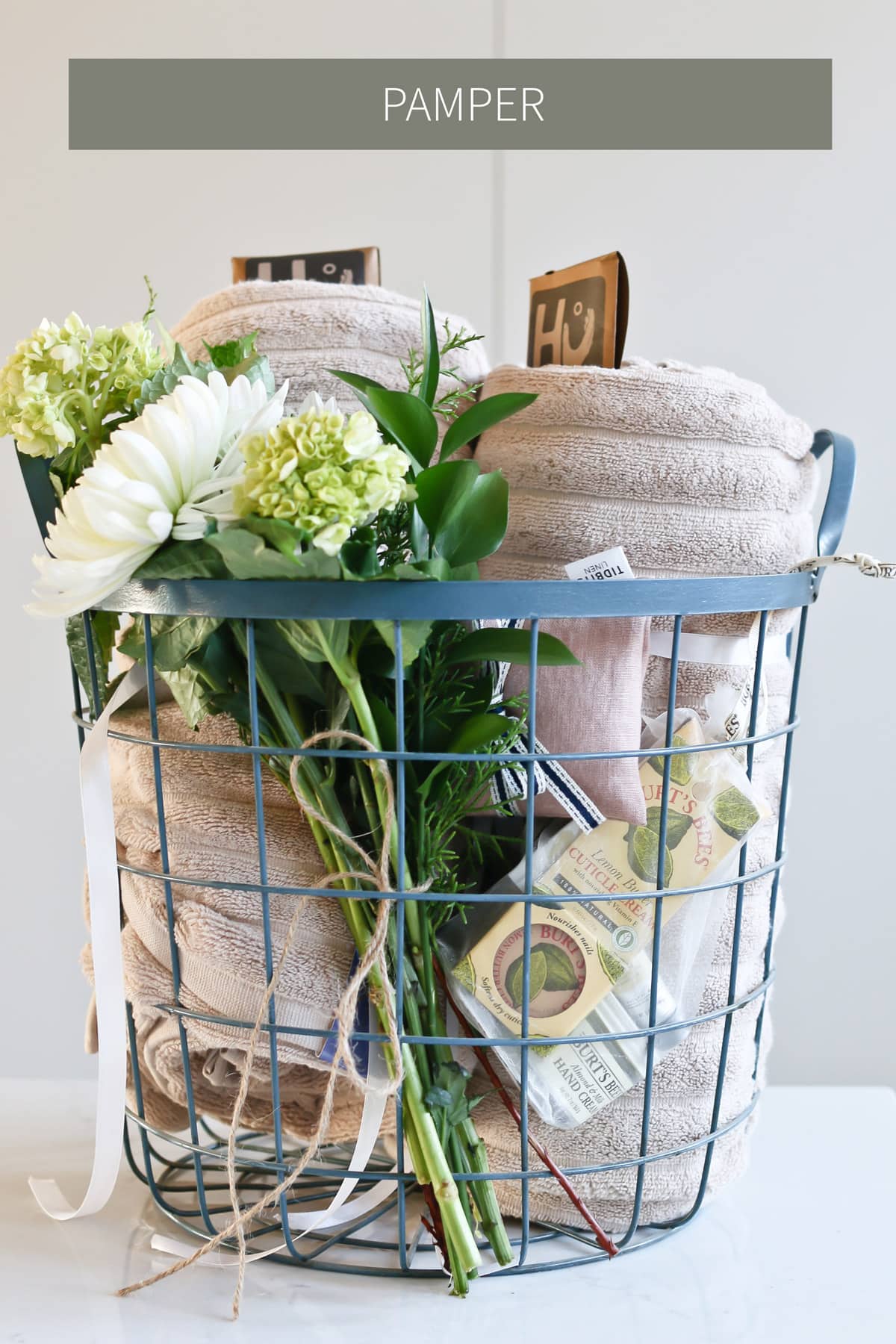 pamper gift basket idea for grandma that includes flowers, chocolate, towels, and skincare products
