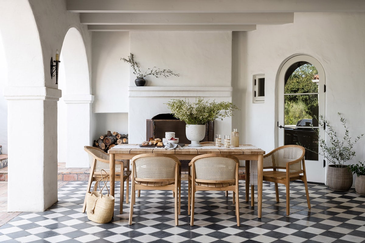 indoor/outdoor space with wooden table and chairs and black and white floor tiles
