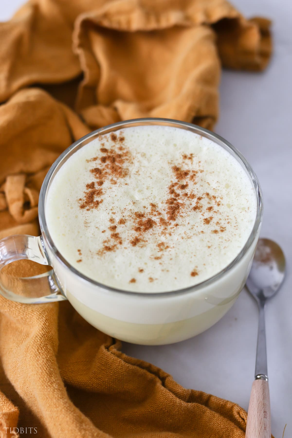 creamy frothy cup of nutritious golden milk, garnished with cinnamon