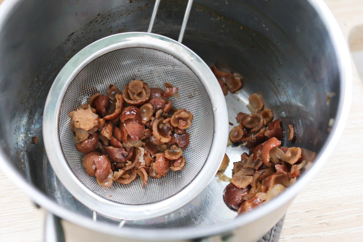 straining the soap nuts after cooking it down.