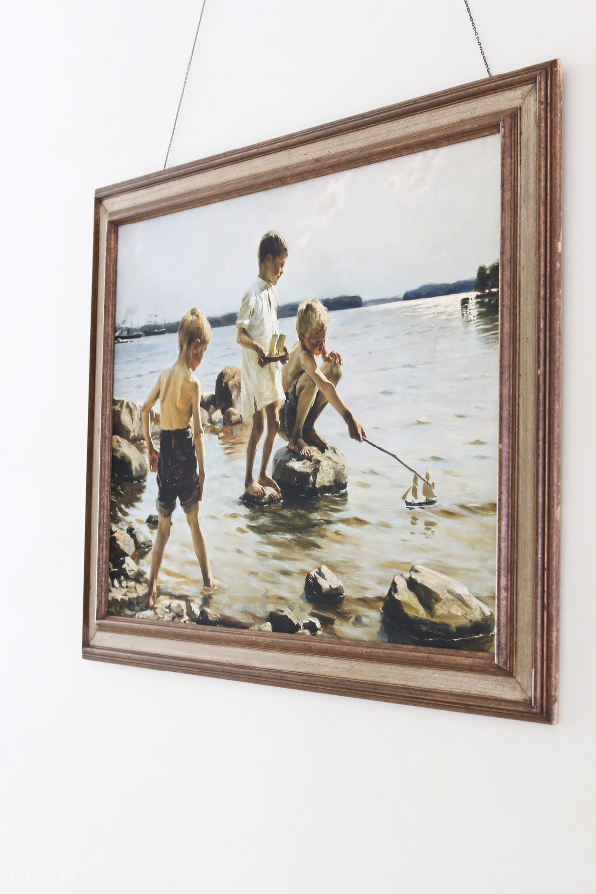 Large painting of boys playing with toy boats in the water