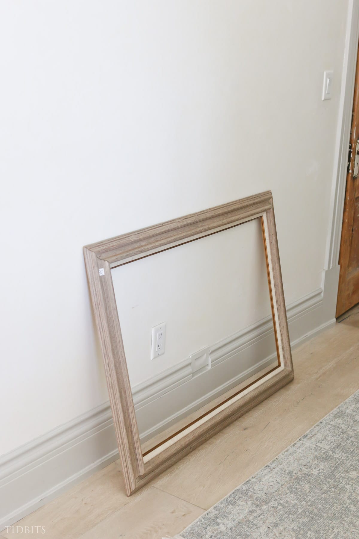 Large, empty art frame sitting on a floor