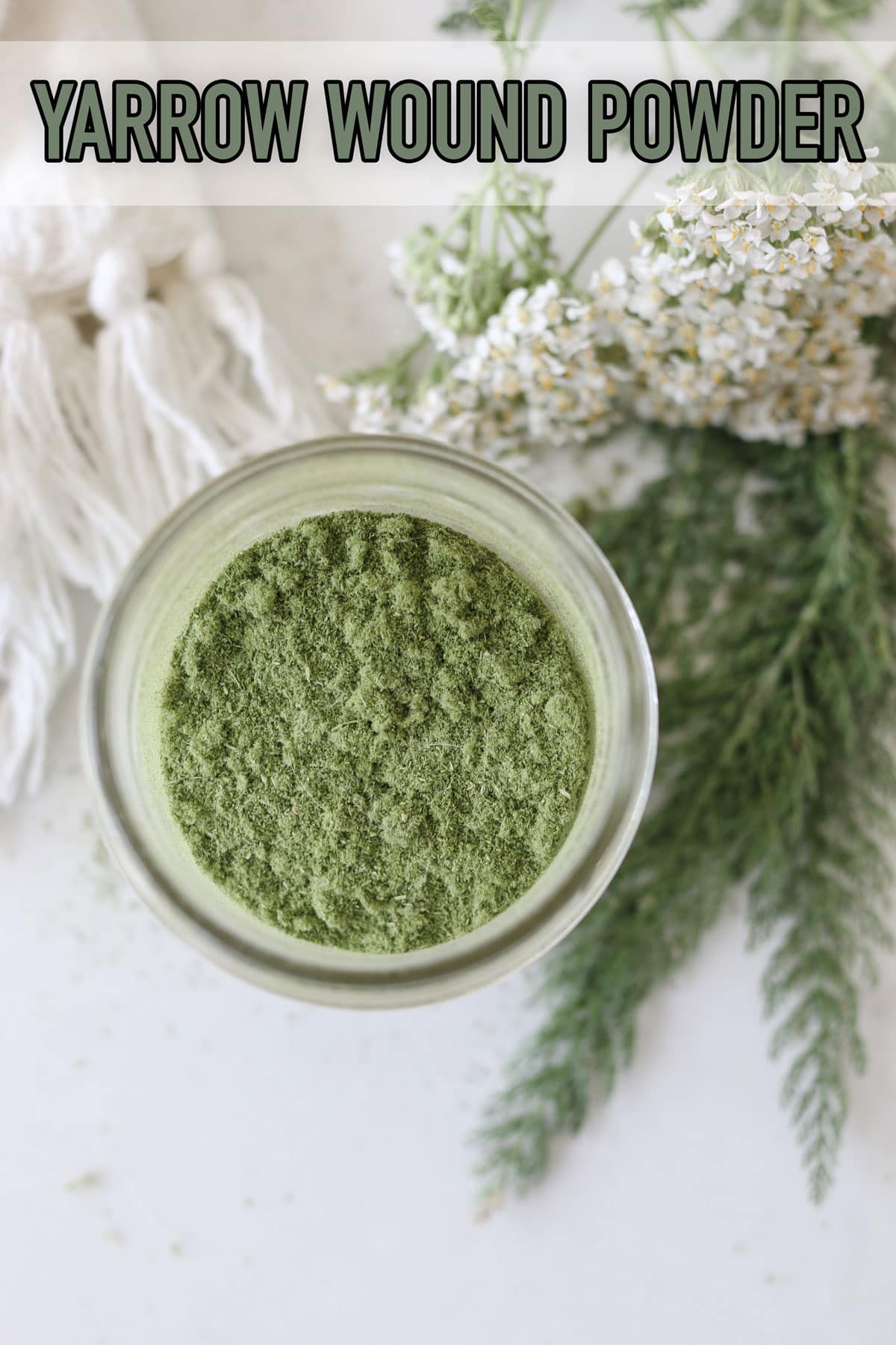 A jar of green yarrow wound powder with leaves and flowers
