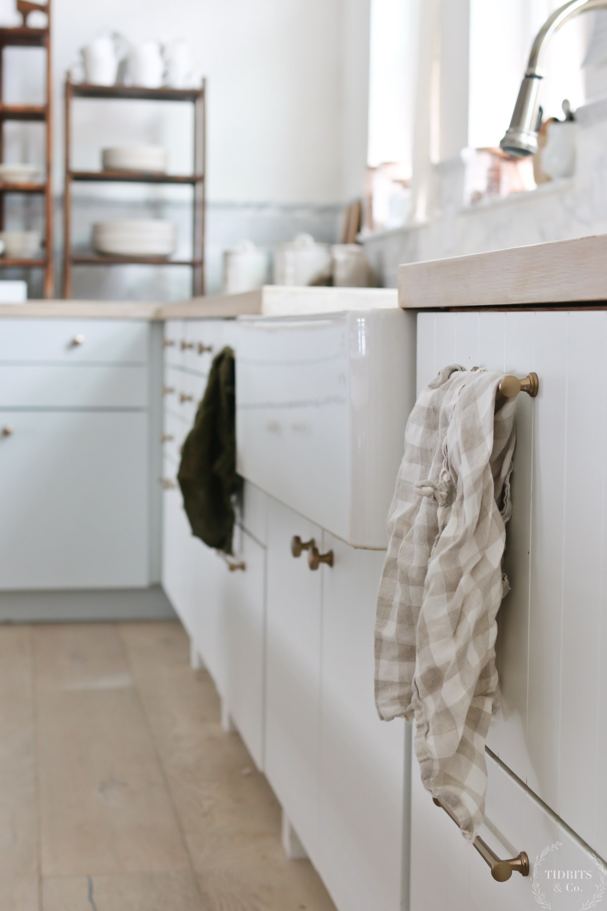 Linen tea towels in fall colors hang in a farmhouse kitchen