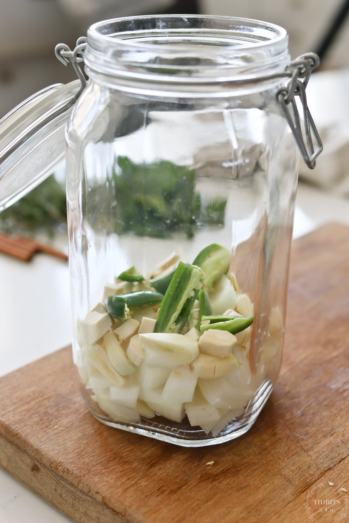 A glass jar layered with onions, garlic and peppers