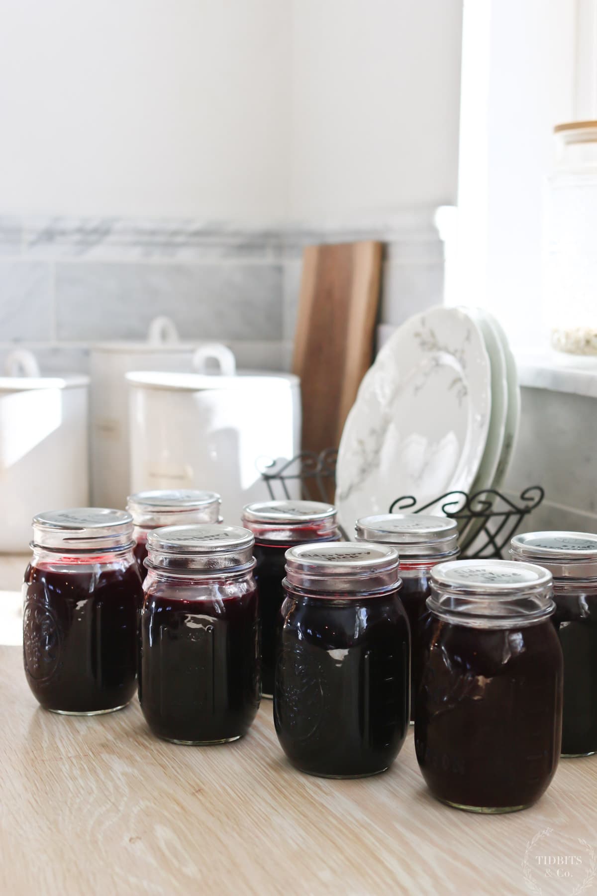 Bottles of juice in pint jars on a kitchen counter