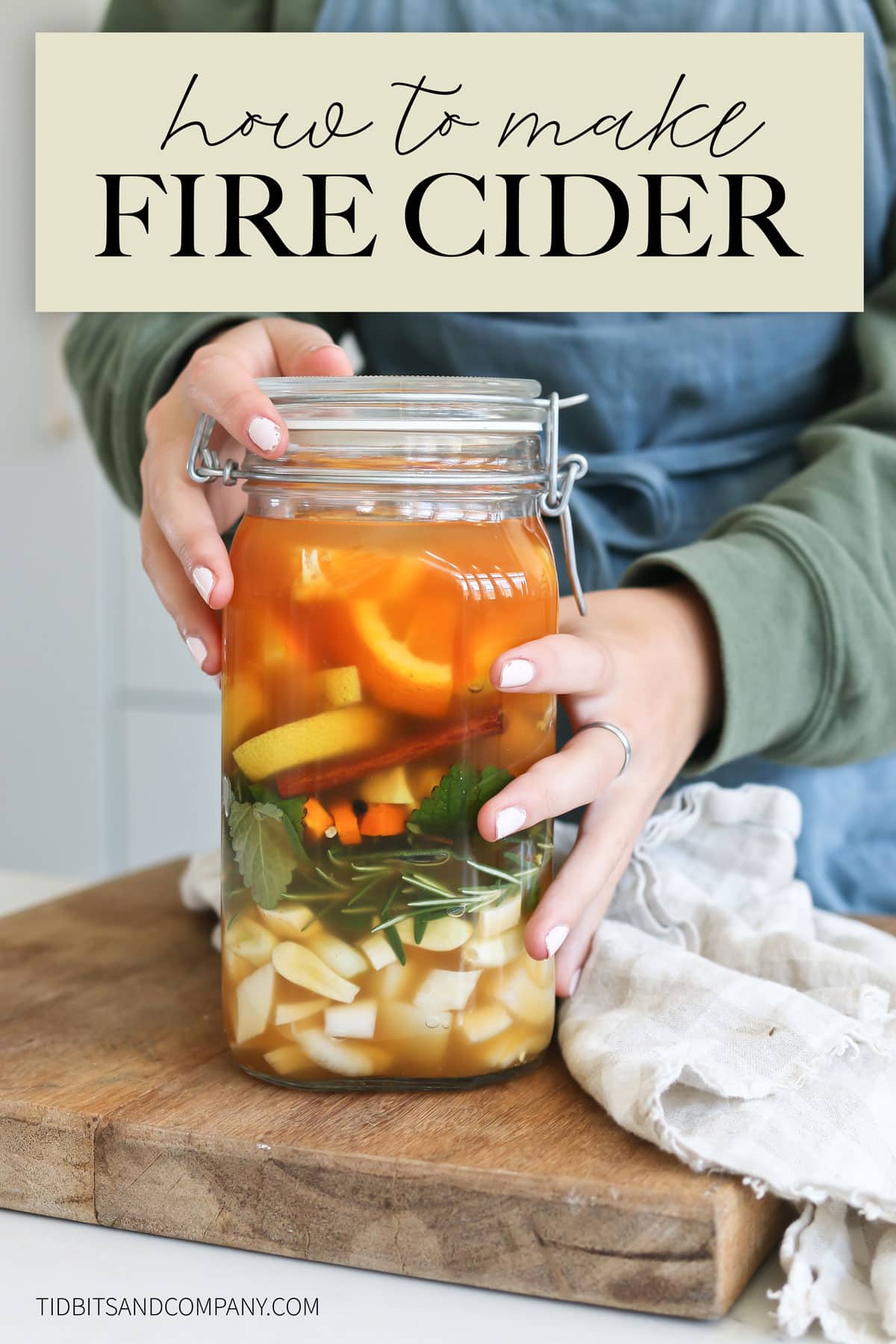Text of "how to make fire cider" over a picture of fire cider in a jar being held by a girl