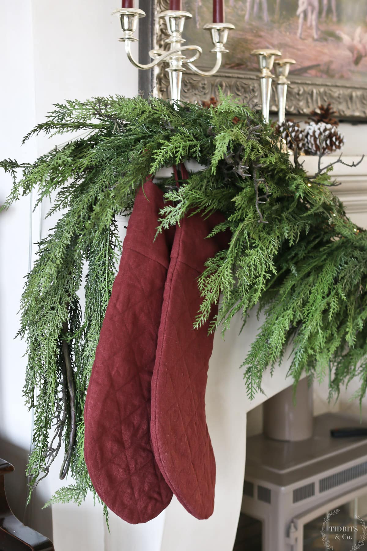 Two red linen stockings hang on a mantel