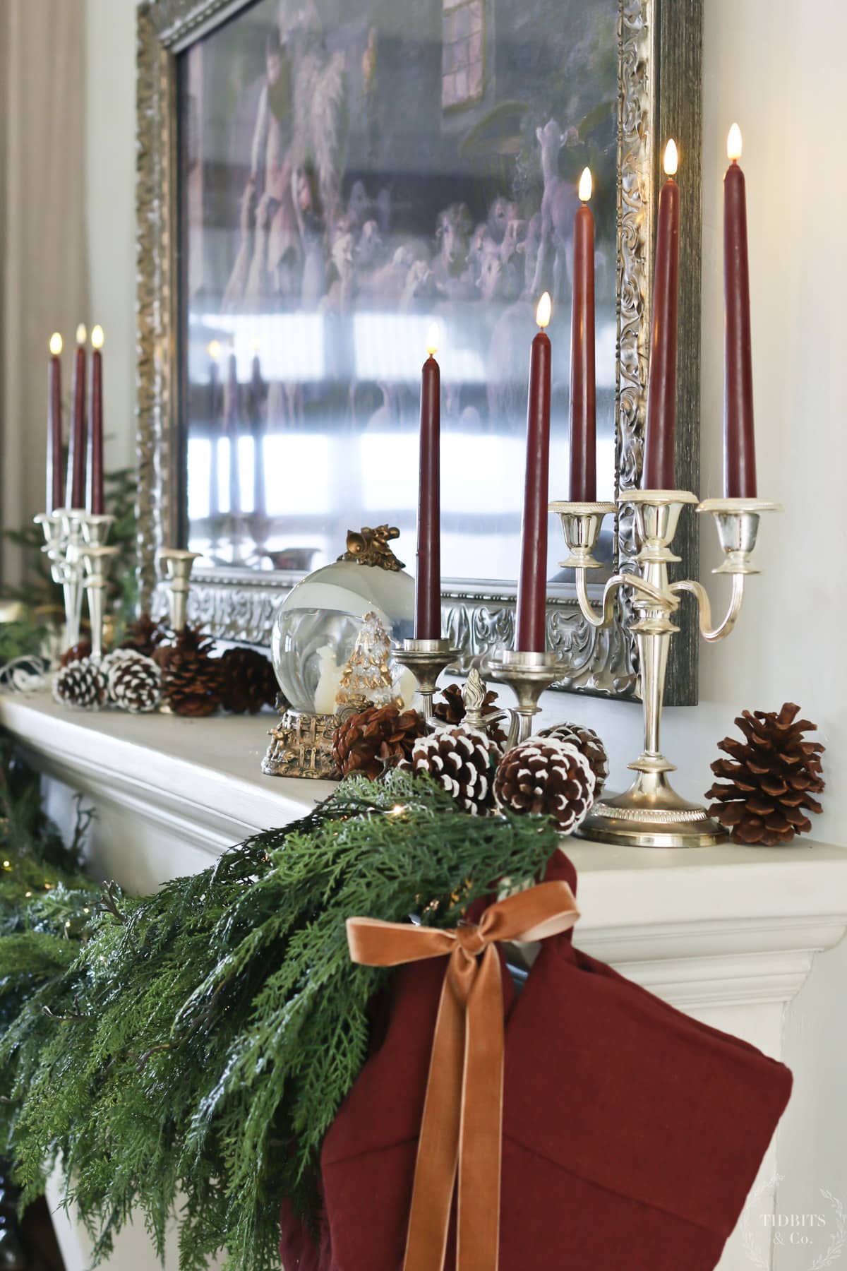 A decorated Christmas mantle with candles and pine cones