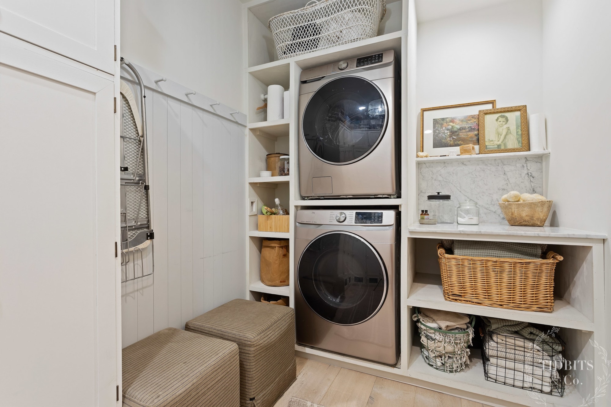 A laundry room with a washer, dryer and baskets for storage