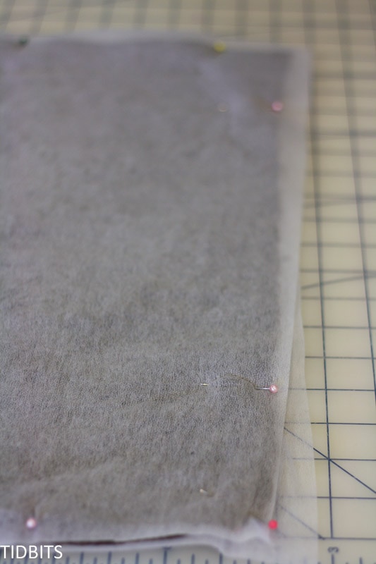 Fusible interfacing is pinned onto knit fabric