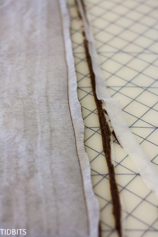 Knit fabric and fusible interfacing are sewn together and excess fabric trimmed off