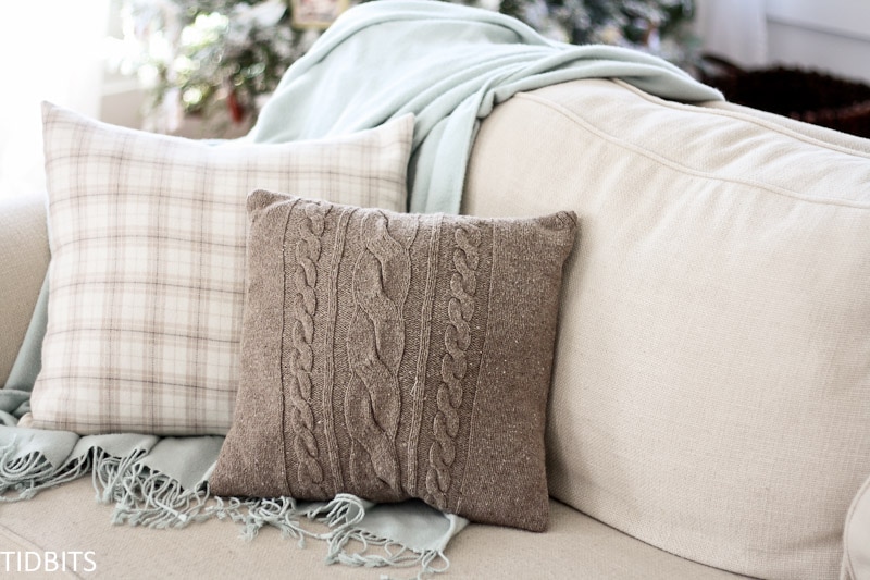 A cozy winter couch with a blanket and pillows
