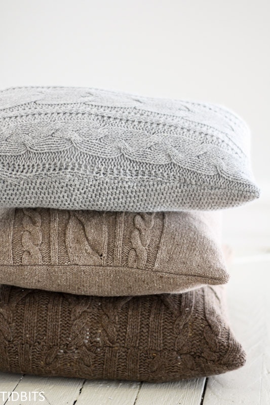  A stack of knit sweater pillows in neutral colors