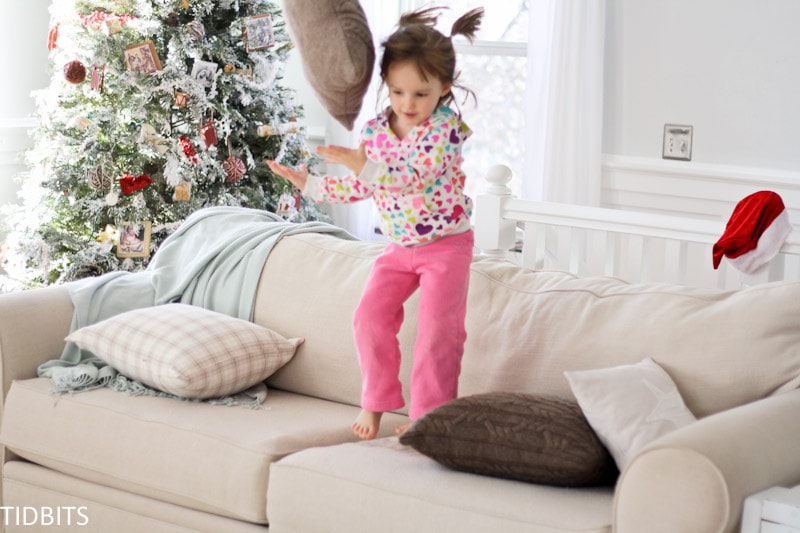 Little girl jumps on a couch