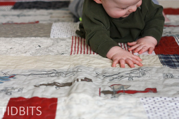 Baby boy playing on a quilt