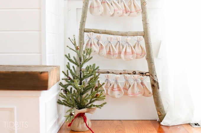 Christmas Countdown grain sack bags hanging on a log ladder. Pattern and tutorial available - by TIDBITS.
