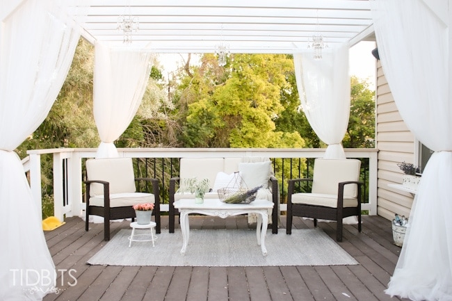 Curtained pergola on a deck for a beautiful and cozy retreat.  Deck makeover by TIDBITS.