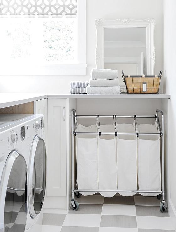 An organized laundry room with a rolling laundry hamper