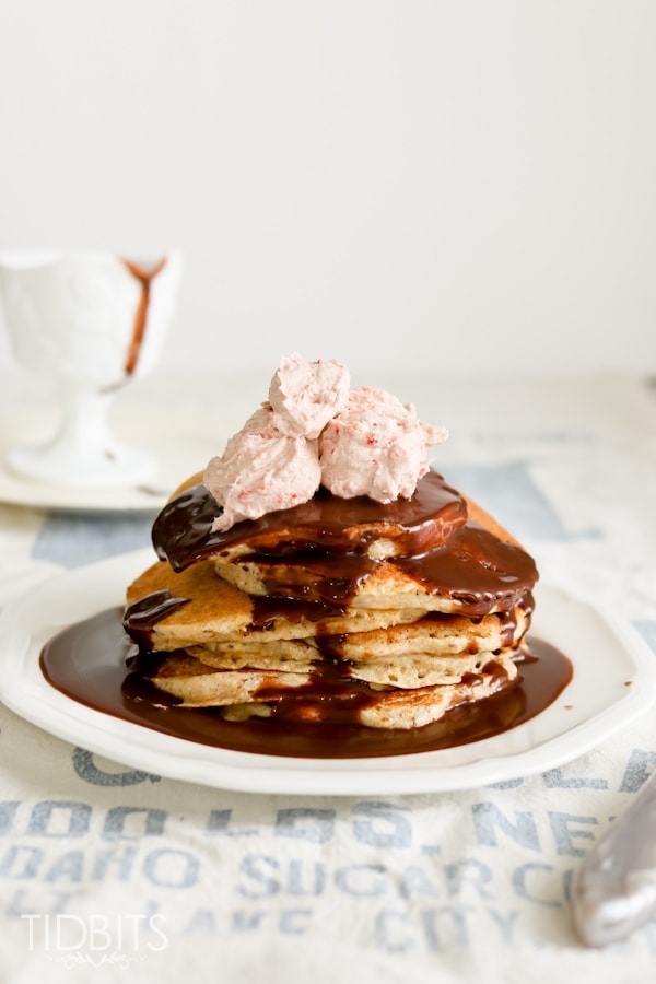 multigrain pancake with chocolate syrup and strawberry whipped cream on top
