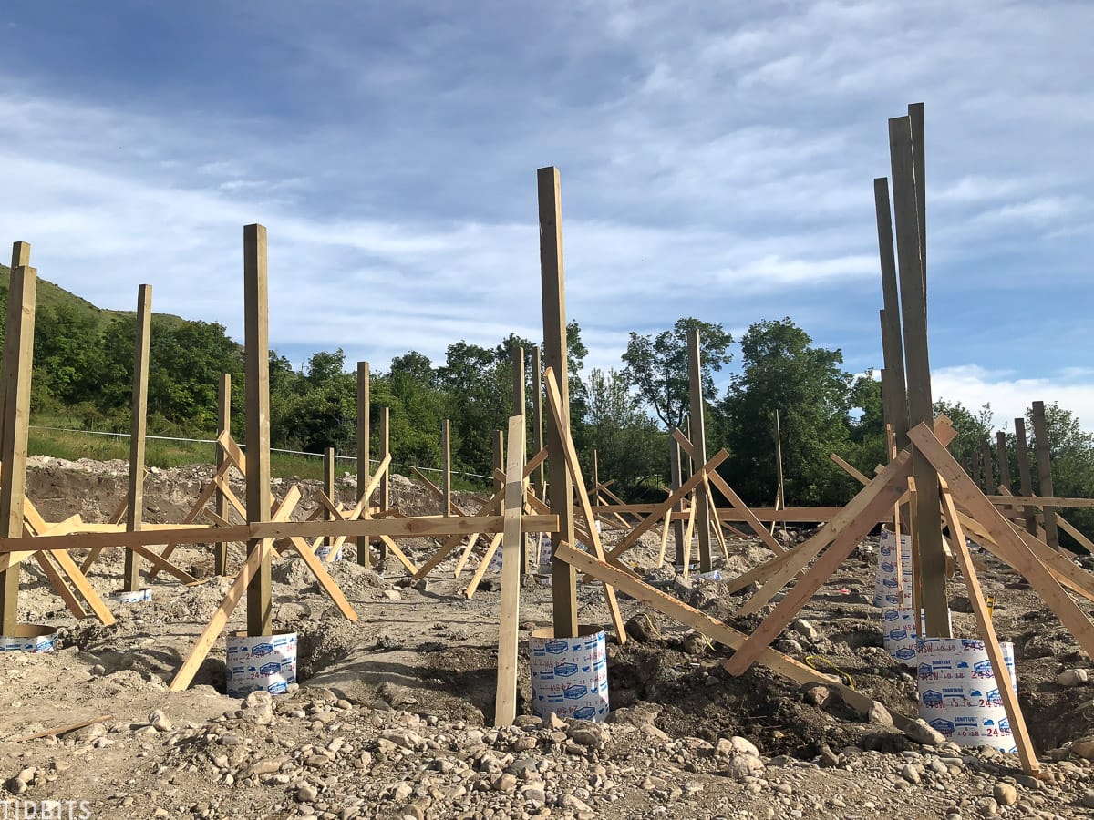 Placing the beams into the ground for our pole barn home.