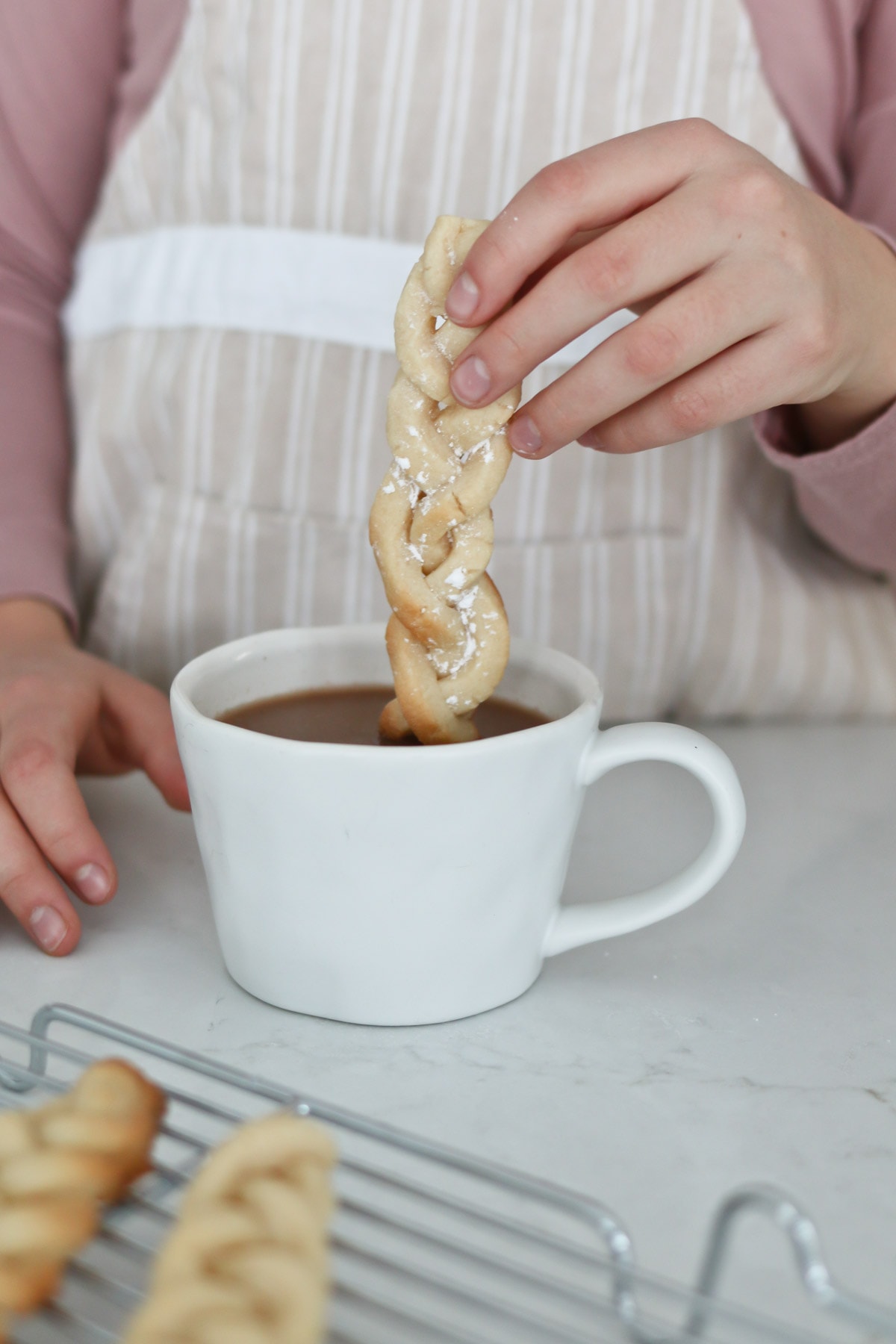 Dipping cookie sticks in hot cocoa