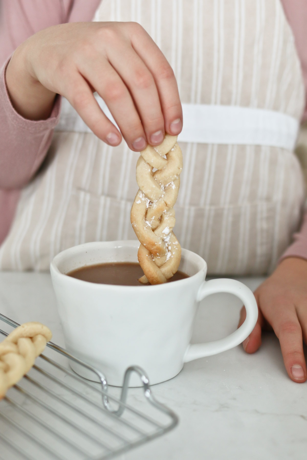 Dipping cookie sticks in hot cocoa