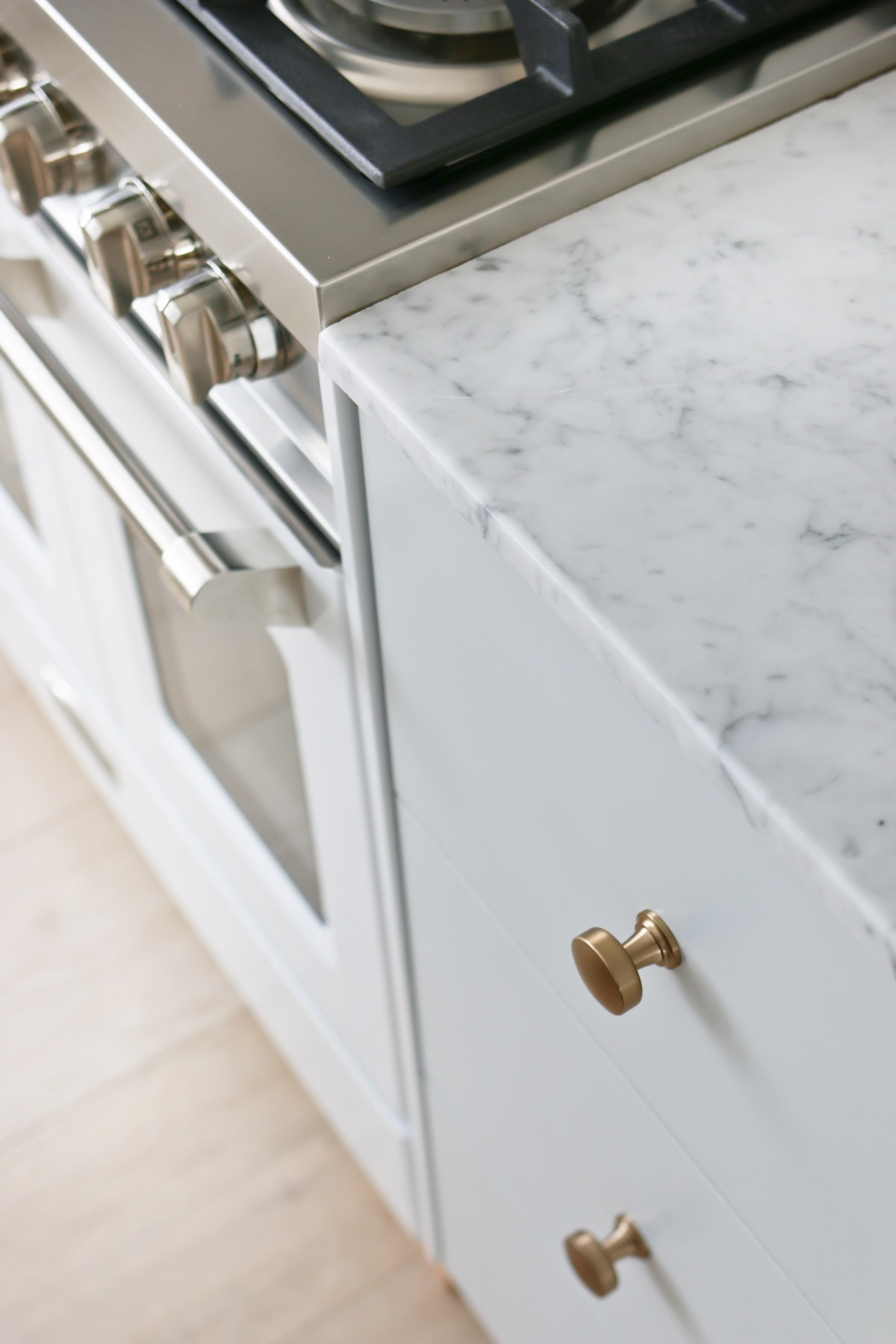 white kitchen drawers and marble counter