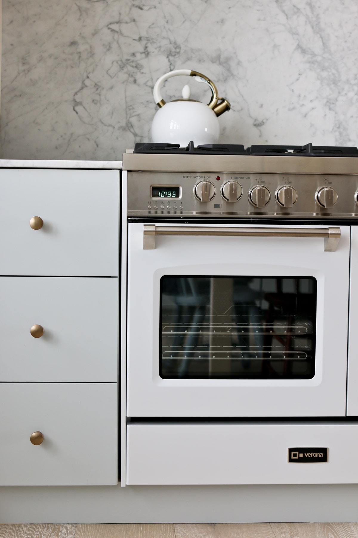verona stove with white kettle on top beside white kitchen drawer