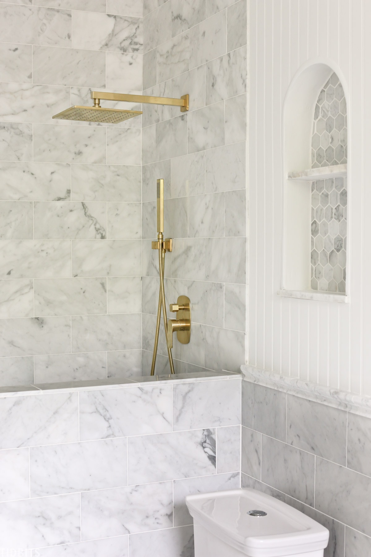 gold fixtures in marble bathroom