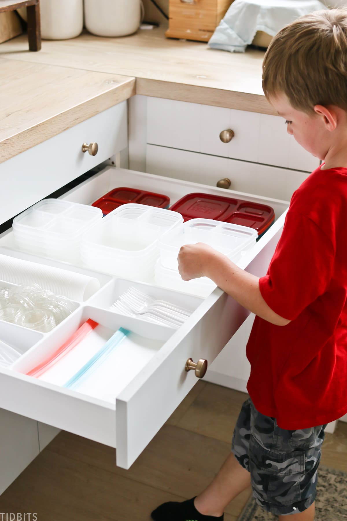 young boy grabs plaster container from kitchen drawer