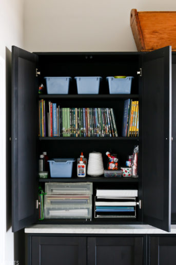 cupboard for homeschooling supplies like paper, binders, blue, and books
