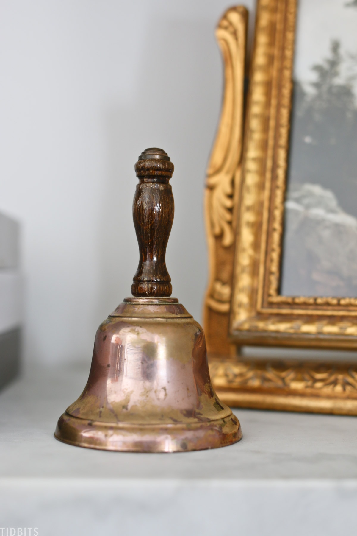vintage school bell on shelf next to mirror