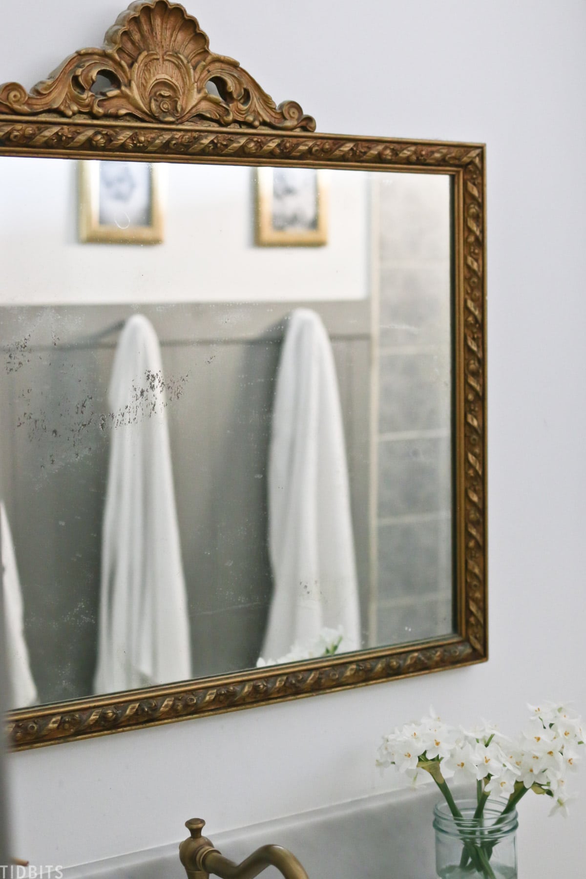mirror with bronze colored frame above bathroom sink in split bathroom