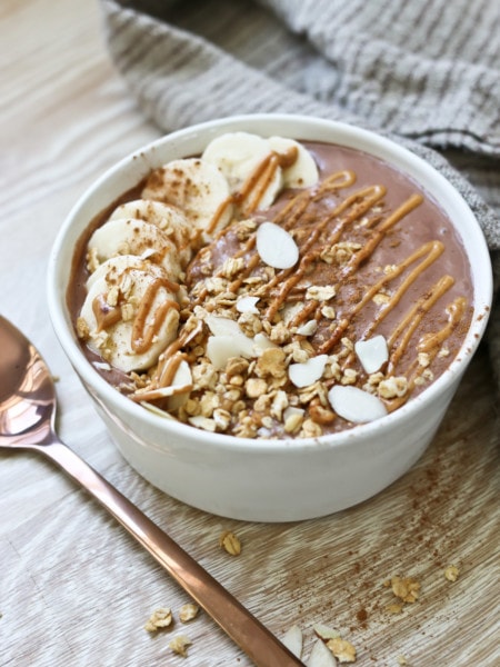 chocolate peanut butter smoothie bowl with banana slices and slivered almonds for garnish