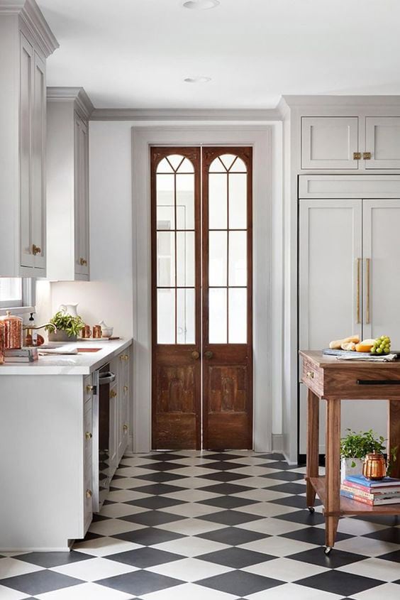 modern kitchen design with black and white flooring and classic elements like a wooden french door