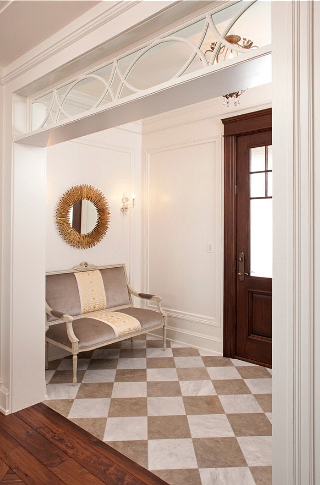 entryway that has brown and white stone floor tiles which blend with the surrounding wood tones and white walls