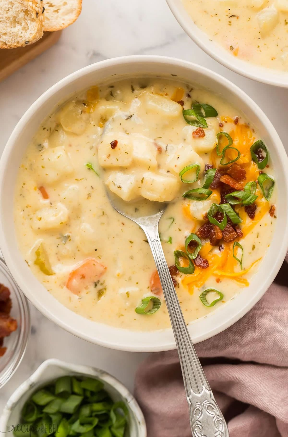 Creamy potato soup recipe in a bowl with bacon, green onions and cheddar cheese