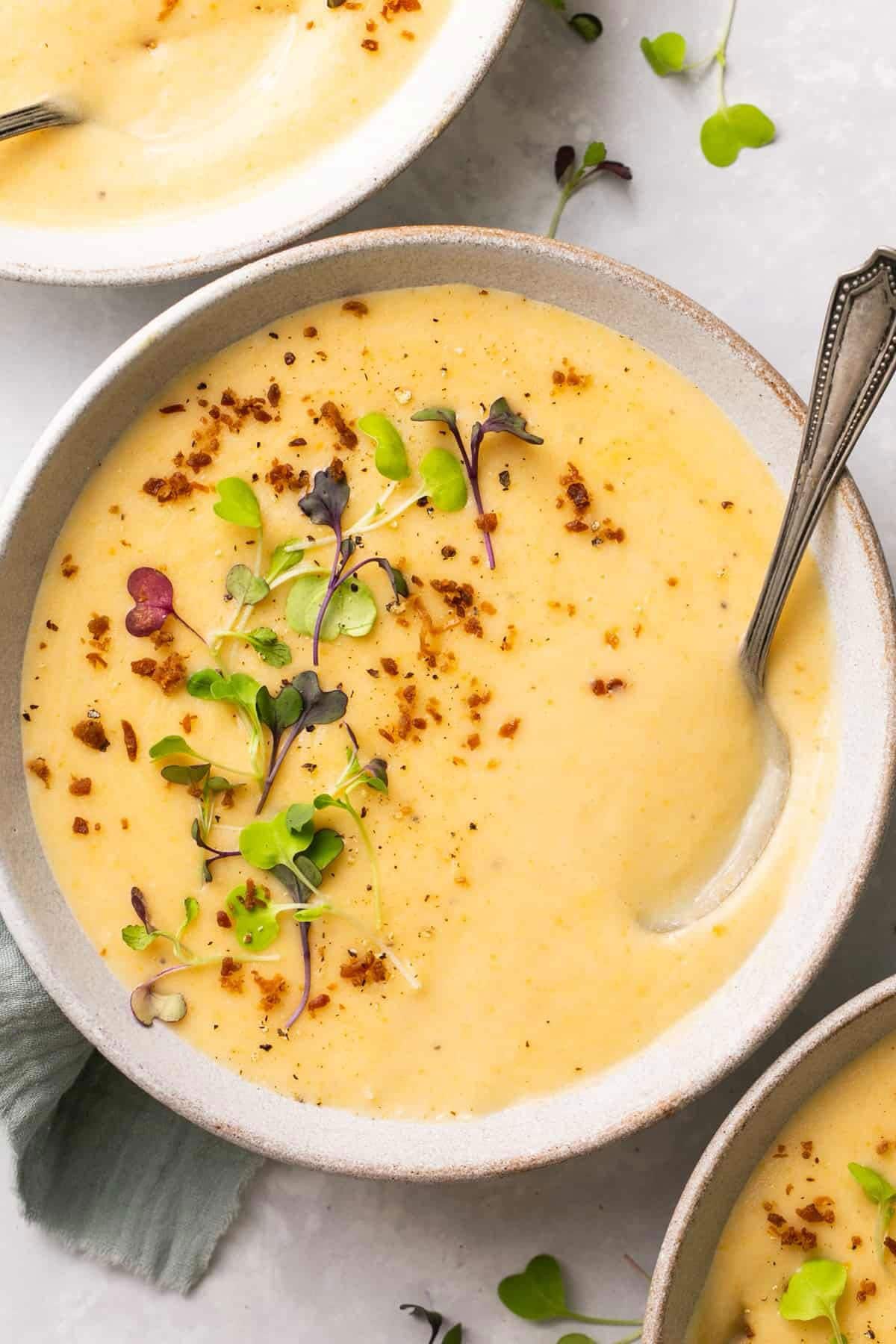A bowl of silky smooth potato soup with herb garnish