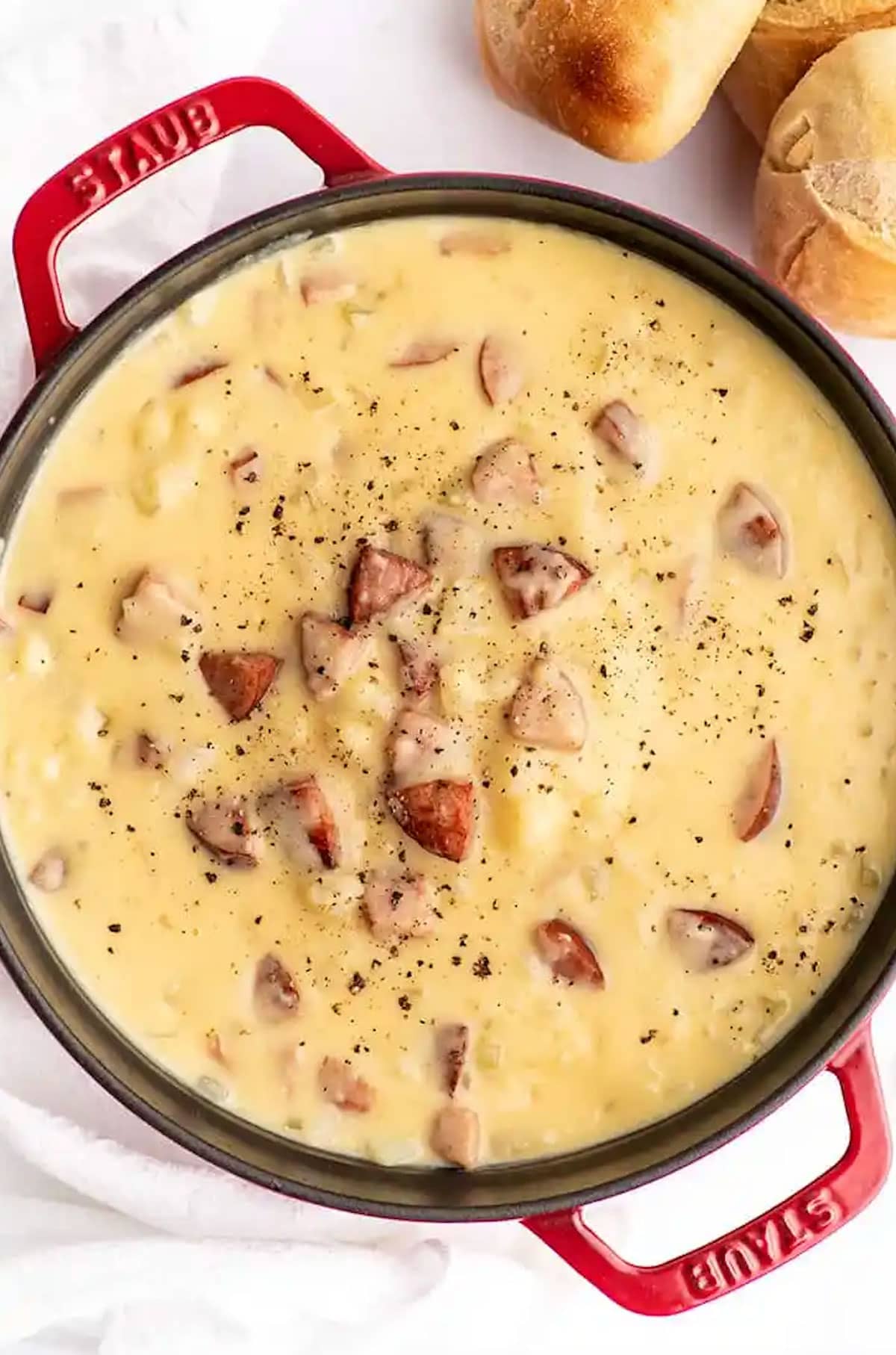 Pot of cheesy sausage and potato soup with pepper garnish