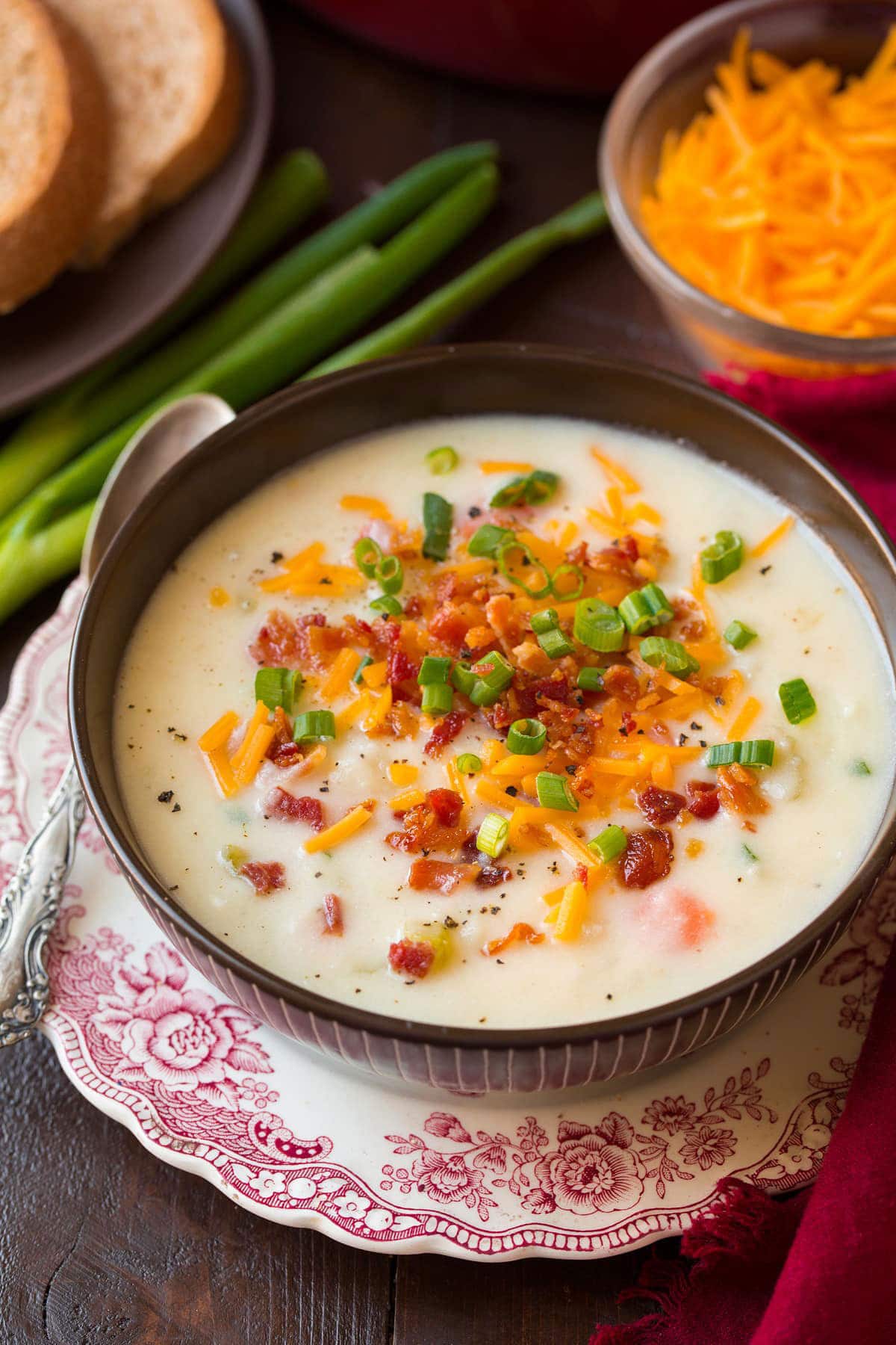 Creamy potato soup recipe in a bowl garnished with green onion, cheese, and bacon