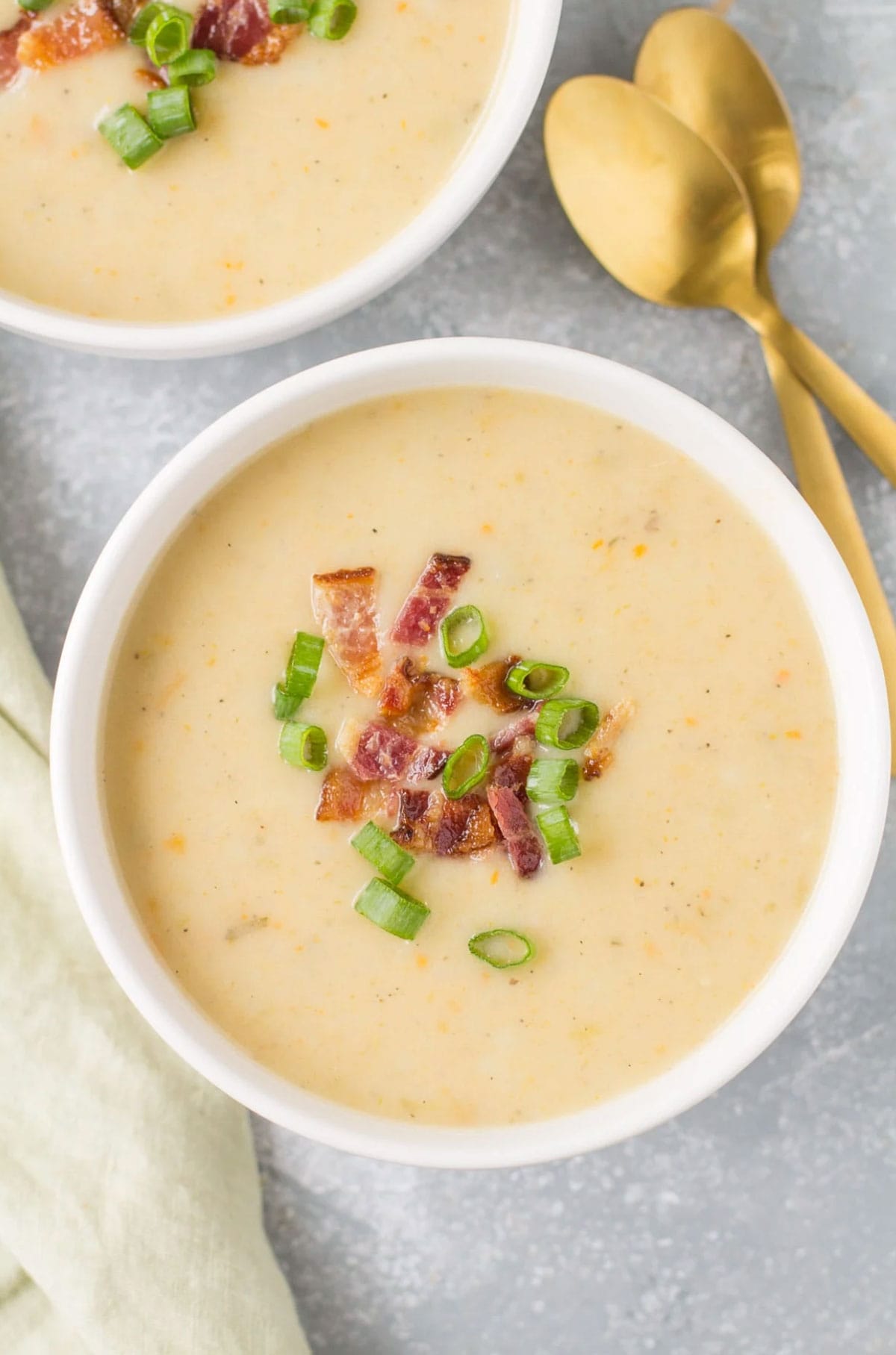 Bowl of healthy potato soup with sprinkle of green onions and bacon bits