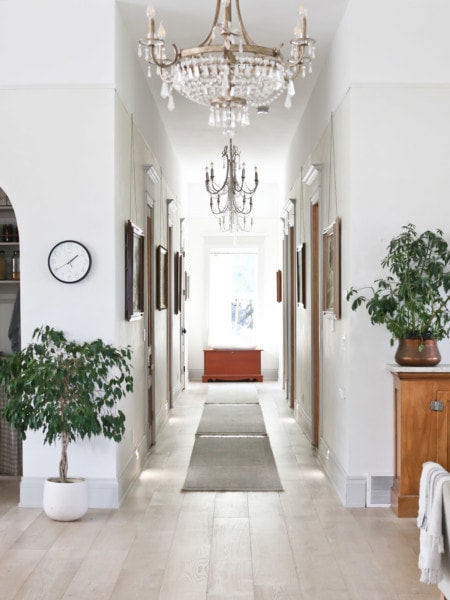 Hallway with large wall art, doors and chandeliers