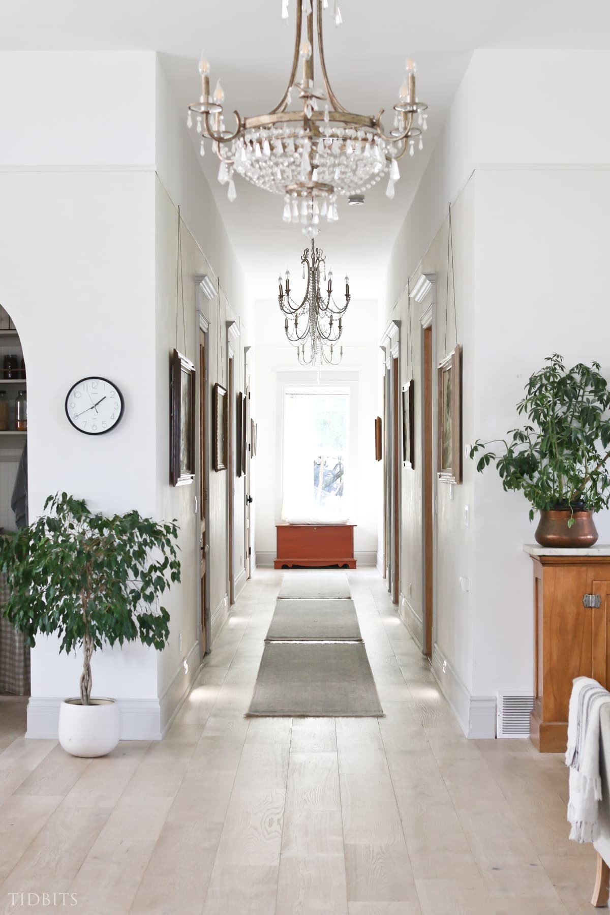 Hallway with large wall art, doors and chandeliers