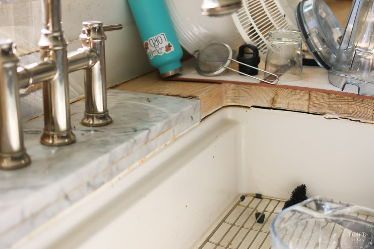 A wood countertop with separation from sink and discoloration